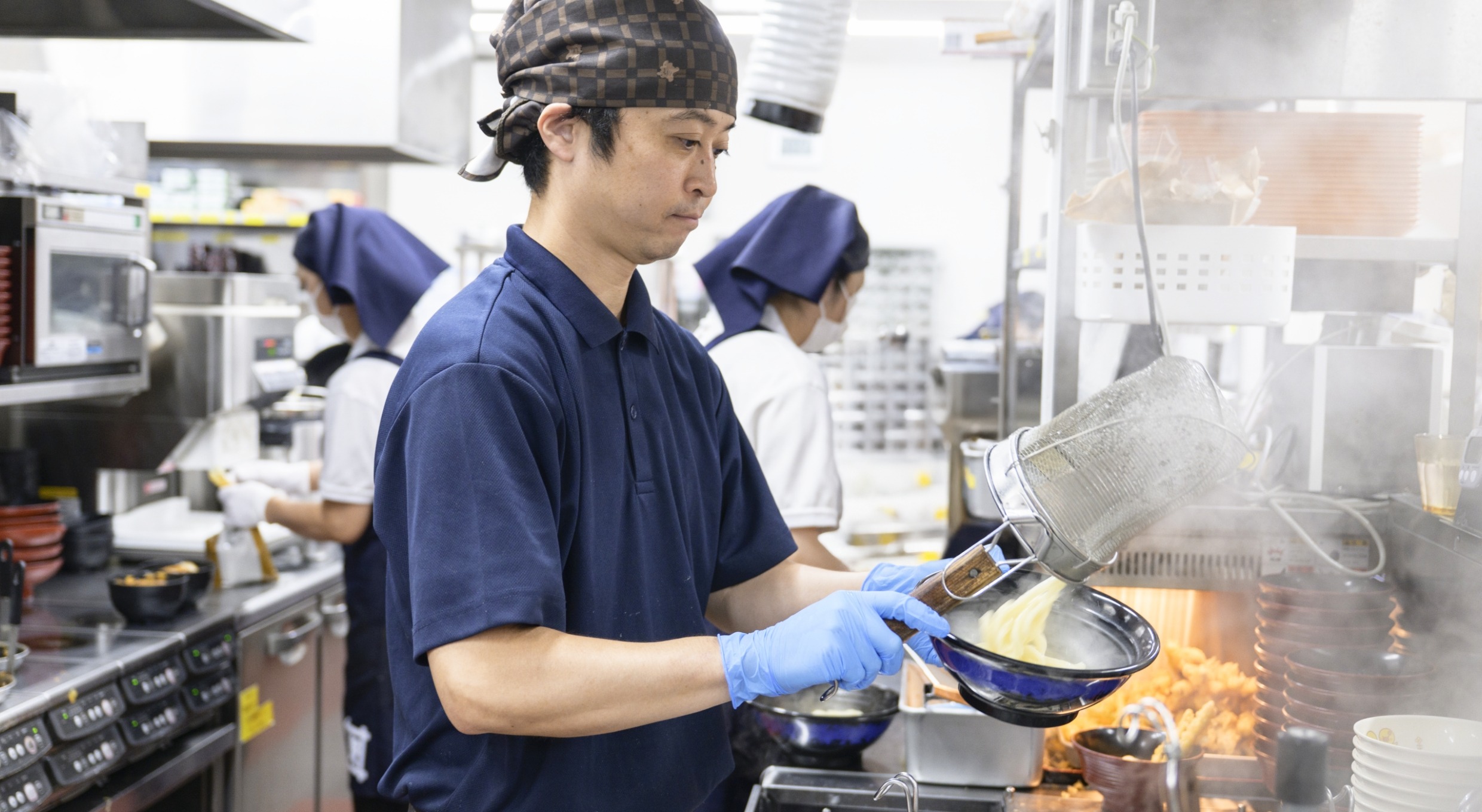 奈良岡さんがうどんを盛り付ける様子