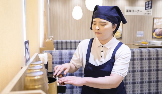 スタッフがテーブルの片付けをする様子